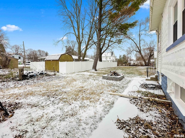 snowy yard with a storage shed