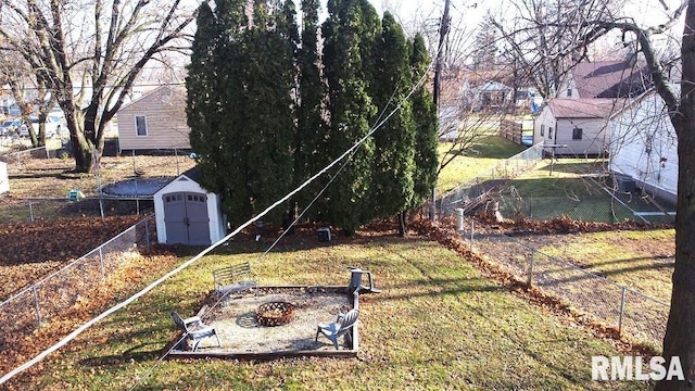 view of yard featuring a fire pit and a storage unit