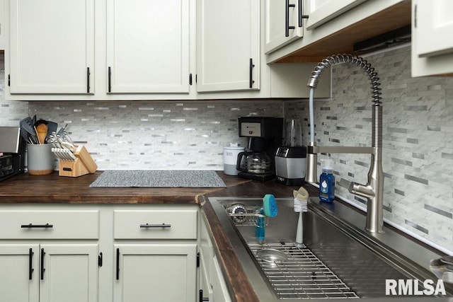 kitchen with backsplash, white cabinets, and wood counters