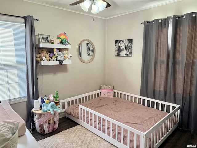 bedroom with dark hardwood / wood-style floors, ceiling fan, and ornamental molding