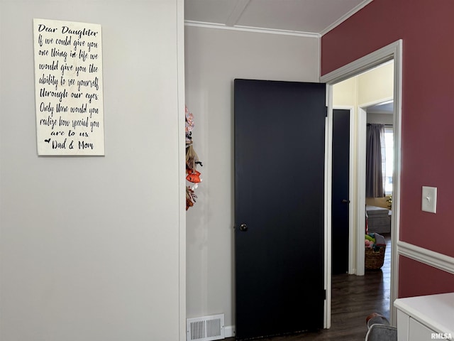 corridor with ornamental molding and dark wood-type flooring