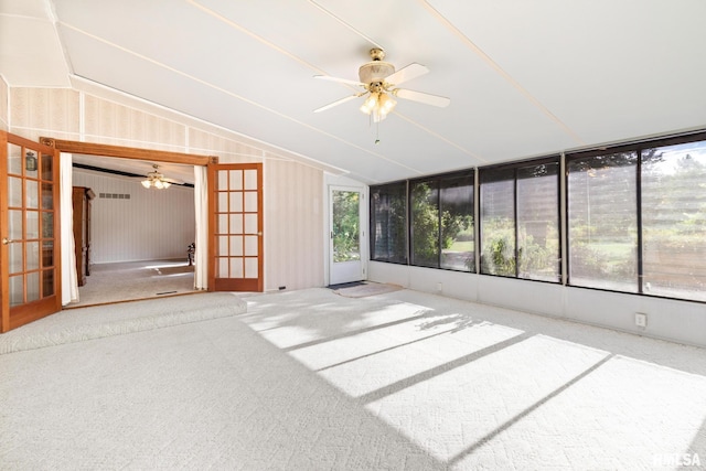 unfurnished sunroom featuring lofted ceiling, a wealth of natural light, and french doors