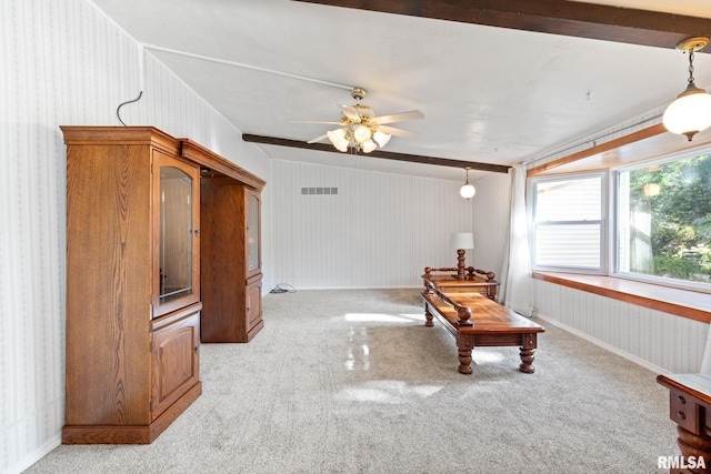 sitting room with beamed ceiling, light colored carpet, and ceiling fan