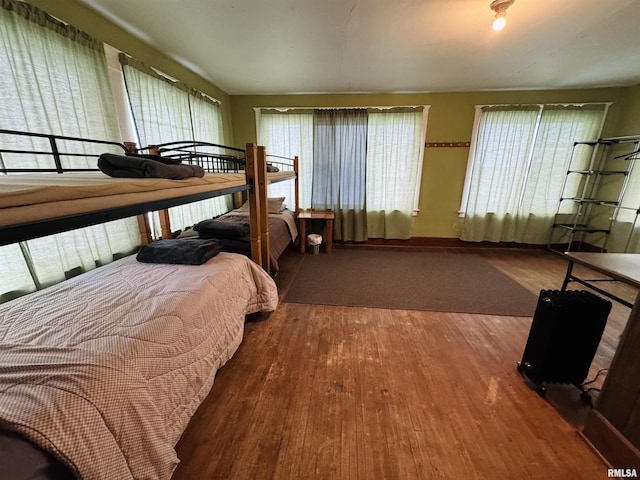 bedroom featuring wood-type flooring and multiple windows