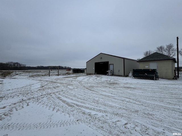 snow covered structure with a garage