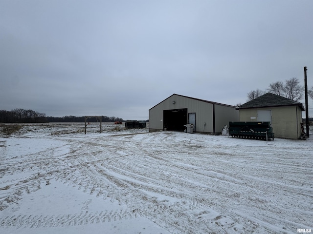 snow covered structure with a garage