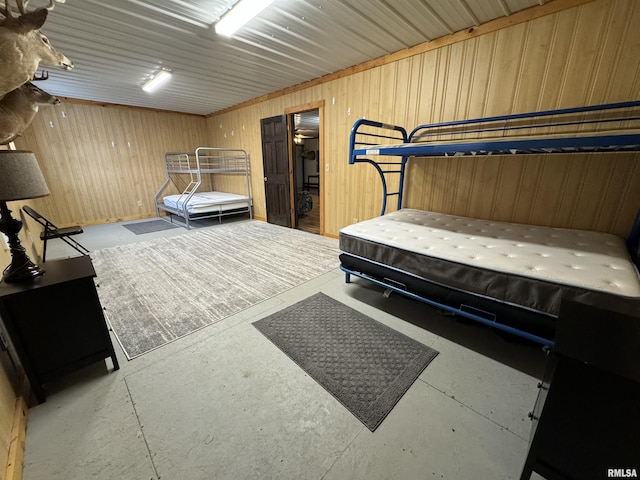 bedroom featuring wood walls and concrete flooring