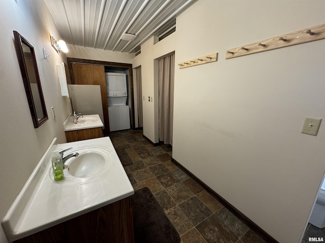 bathroom with vanity and stacked washing maching and dryer