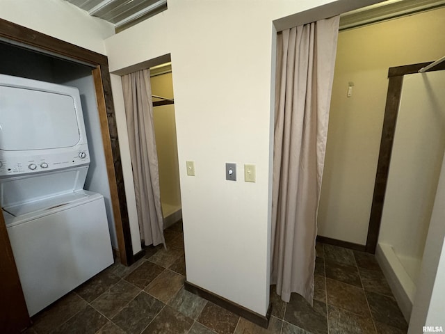 clothes washing area featuring stacked washer / dryer