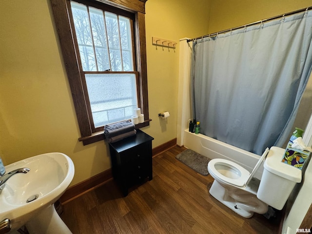 full bathroom featuring toilet, wood-type flooring, sink, and shower / tub combo