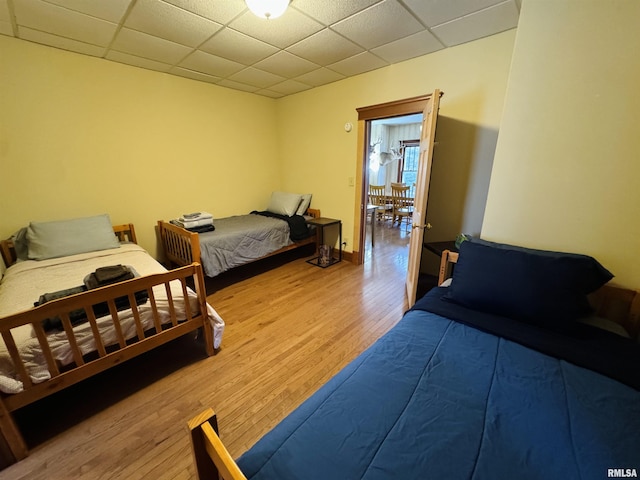 bedroom featuring a paneled ceiling and wood-type flooring