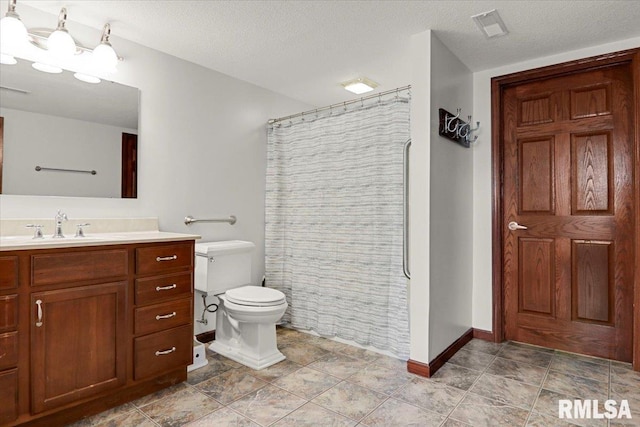 bathroom with curtained shower, vanity, a textured ceiling, and toilet