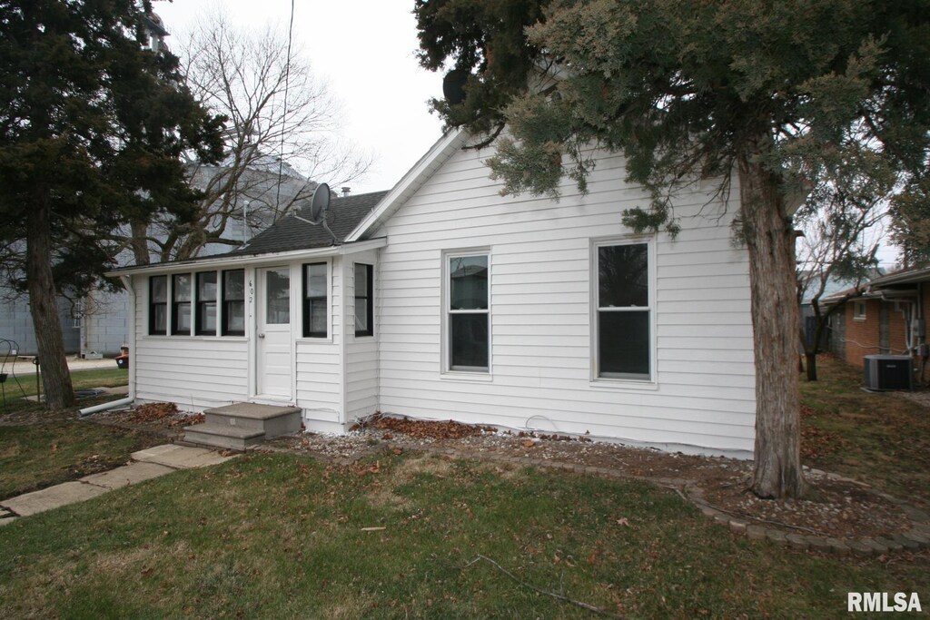 bungalow featuring cooling unit and a front yard