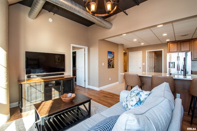 living room with light hardwood / wood-style flooring and a notable chandelier