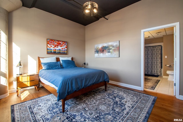 bedroom with hardwood / wood-style flooring and ensuite bathroom