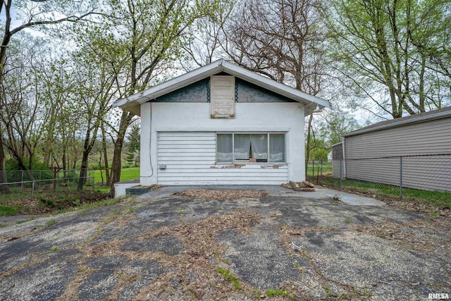 rear view of property featuring stucco siding and fence