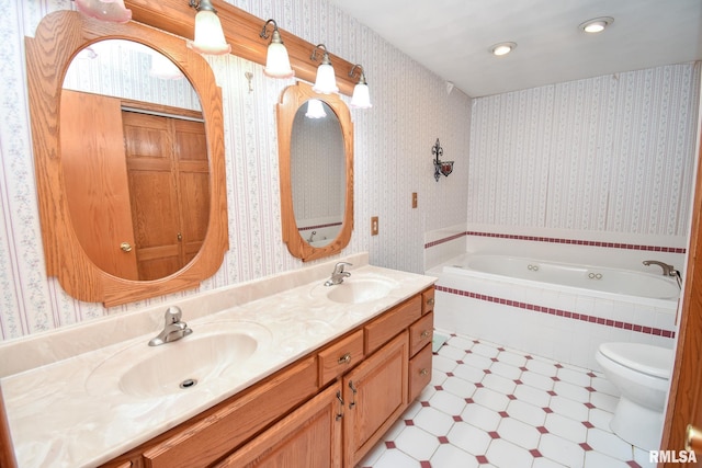 bathroom with tiled bath, vanity, and toilet