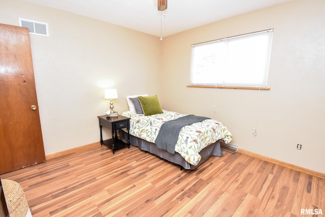 bedroom with light wood-type flooring, visible vents, ceiling fan, and baseboards