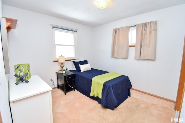 bedroom featuring light carpet and baseboards