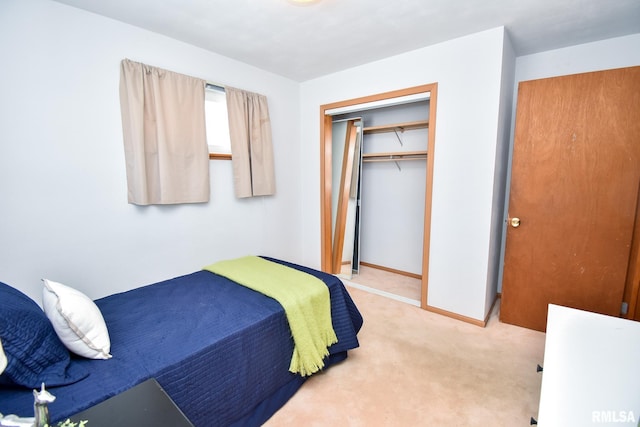 bedroom with baseboards, a closet, and light colored carpet