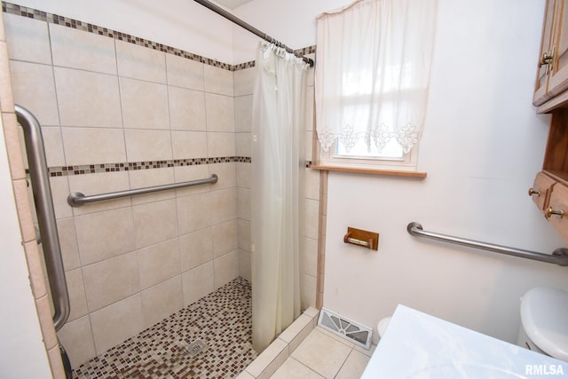 bathroom featuring tile patterned flooring, visible vents, a shower stall, and toilet