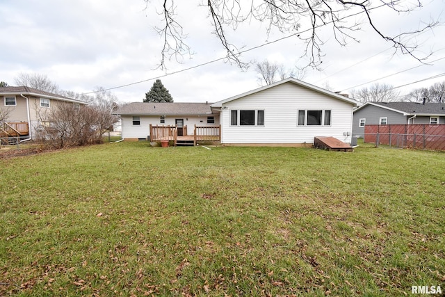 back of property featuring fence, a lawn, and a wooden deck