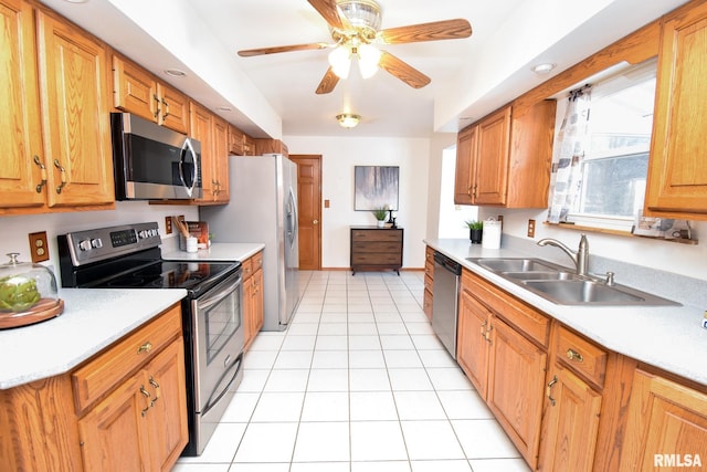 kitchen with stainless steel appliances, brown cabinets, light countertops, and a sink