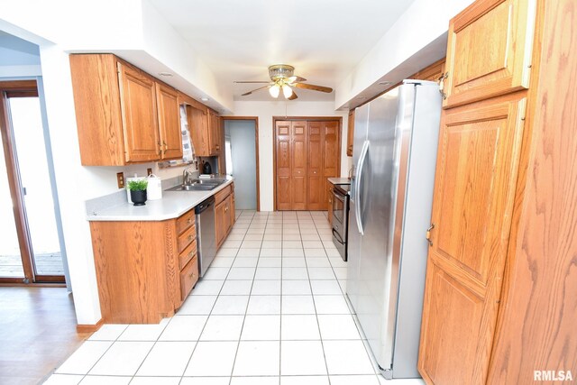 kitchen featuring light tile patterned flooring, appliances with stainless steel finishes, ceiling fan, and sink