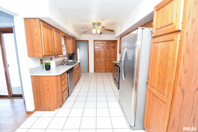 kitchen with light tile patterned floors, ceiling fan, a sink, light countertops, and appliances with stainless steel finishes