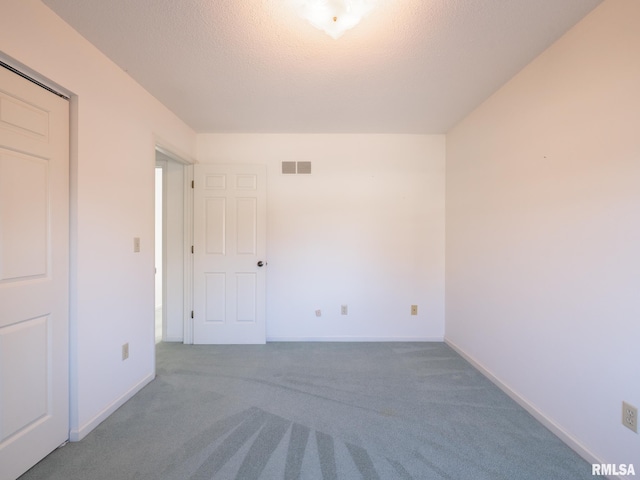 unfurnished room featuring a textured ceiling and carpet