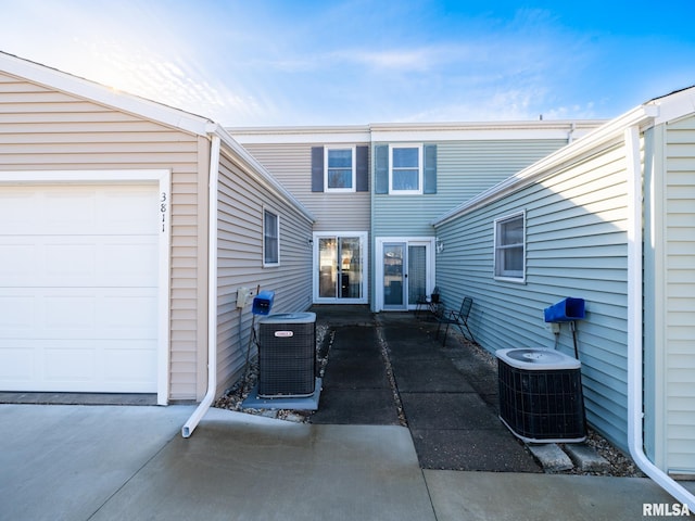 exterior space with a garage and cooling unit