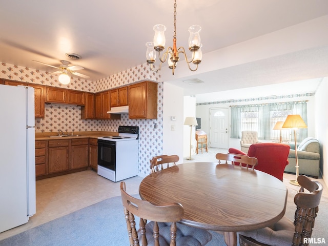 dining room with sink and ceiling fan with notable chandelier