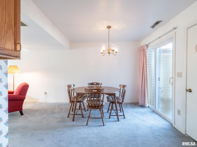 carpeted dining area featuring a chandelier