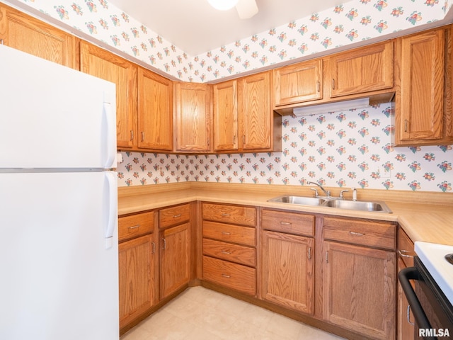 kitchen with white fridge, range, and sink