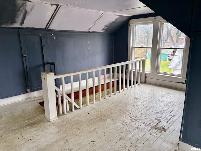 additional living space featuring light hardwood / wood-style floors and vaulted ceiling