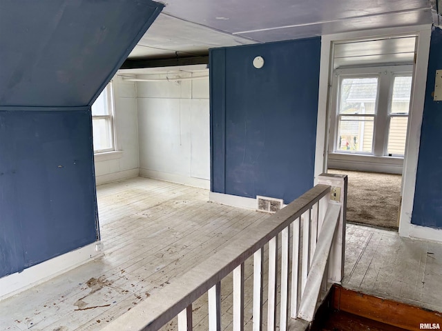 additional living space with plenty of natural light and wood-type flooring