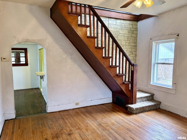 stairway with hardwood / wood-style flooring and ceiling fan