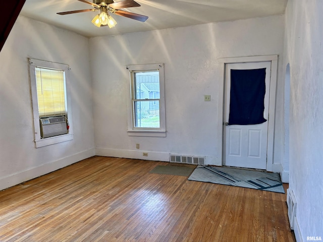 spare room with hardwood / wood-style flooring, ceiling fan, and cooling unit