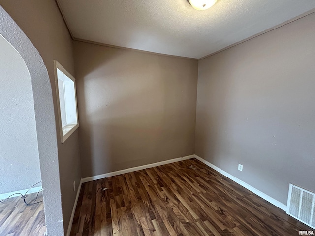 unfurnished room with a textured ceiling and hardwood / wood-style floors