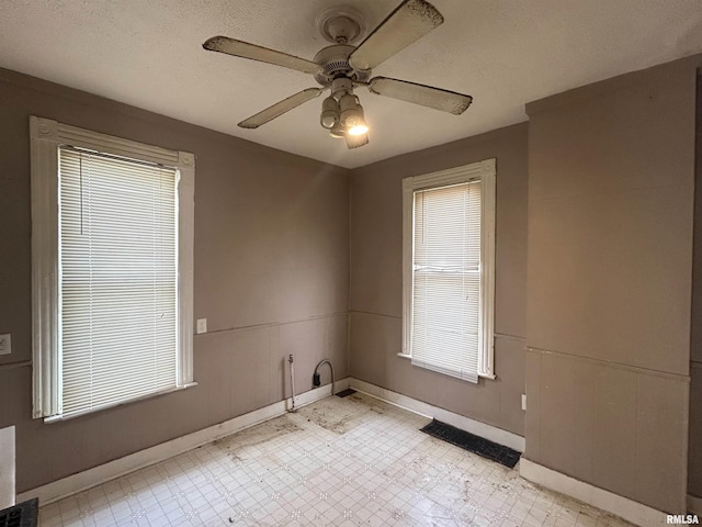 spare room with ceiling fan and a textured ceiling