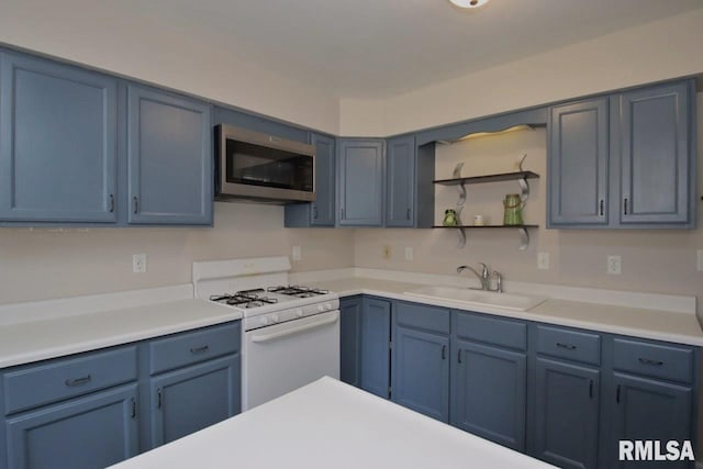 kitchen with blue cabinetry, sink, and white gas range oven