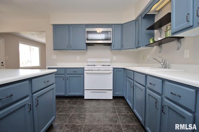 kitchen with blue cabinetry, sink, and white stove