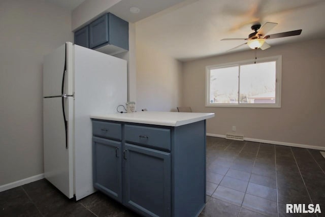 kitchen featuring kitchen peninsula, white refrigerator, dark tile patterned flooring, and ceiling fan