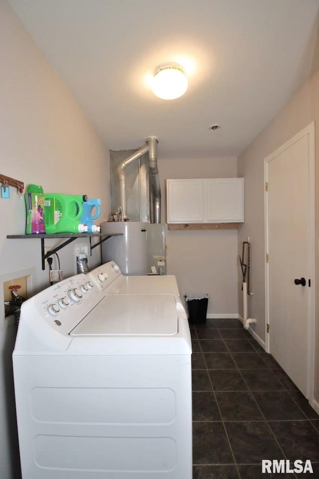 laundry area featuring dark tile patterned floors, gas water heater, and washer and clothes dryer