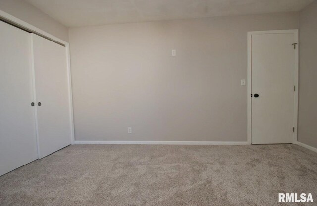 unfurnished bedroom with a closet and light colored carpet