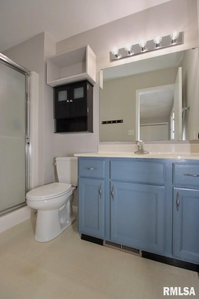 bathroom with vanity, toilet, and an enclosed shower