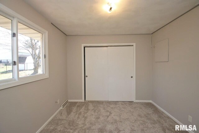 unfurnished bedroom with a closet and light colored carpet