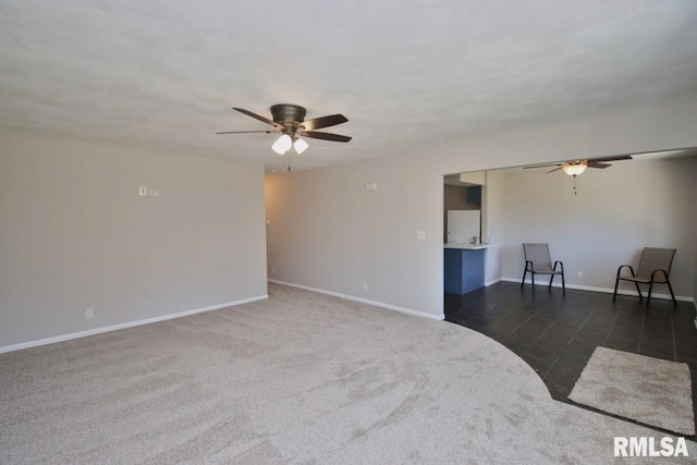 carpeted spare room featuring ceiling fan