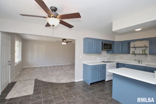 kitchen with dark colored carpet, blue cabinets, white gas stove, and sink