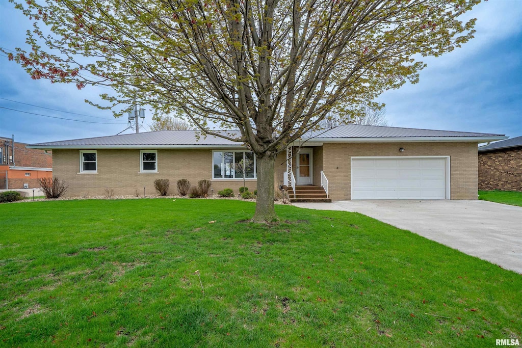 127 S Reiter St, Benson, IL 61516 - ranch-style house featuring brick siding, a garage, metal roof, and concrete driveway